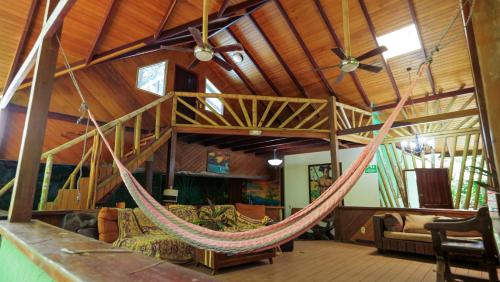 a hammock in the living room of a house at Chosa Manglar Suites & Cabins in Puerto Jiménez