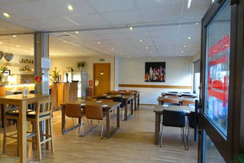 una sala da pranzo con tavoli e sedie in un ristorante di Pizza House Bed Simrishamn a Simrishamn