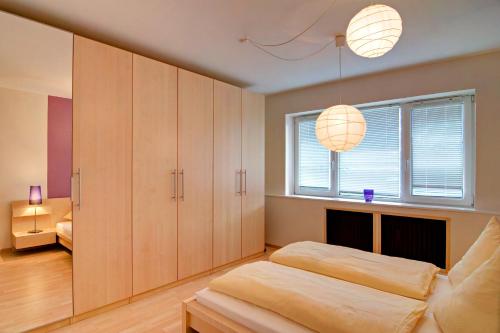 a bedroom with wooden cabinets and a bed and a window at Hotel Am Mühlenteich in Lübeck