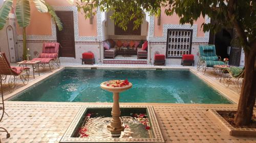 a pool with a fountain in the middle of a building at Riad Barroko in Marrakech