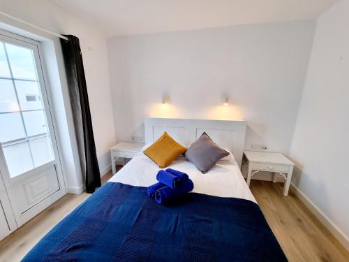 a bedroom with a bed with a blue pillow on it at Luxury Coral Beach first line of the sea in Playa Honda