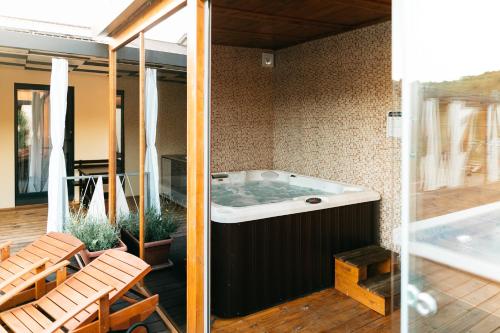 a jacuzzi tub on a patio with chairs at Illyria Apartments in Skradin