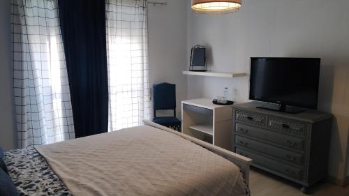 a bedroom with a bed and a television on a dresser at Forever São Brás in São Brás de Alportel