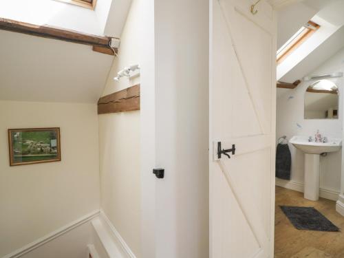 La salle de bains est pourvue d'une porte blanche et d'un lavabo. dans l'établissement Swallows Nest, à Carlisle