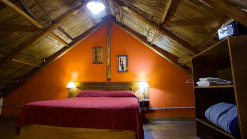 a bedroom with a red bed in a attic at La Aldea in San Rafael
