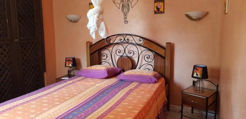 um quarto com uma cama com duas almofadas em Résidence Safari Village em Saly Portudal