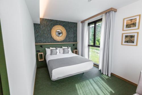 a bedroom with a large bed and a window at Hotel Ecos del Sella in Cangas de Onís