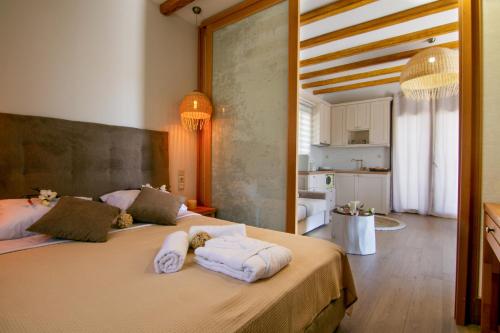 a bedroom with two beds with towels on them at Aphrodite Stone Apartments in Moúdhros