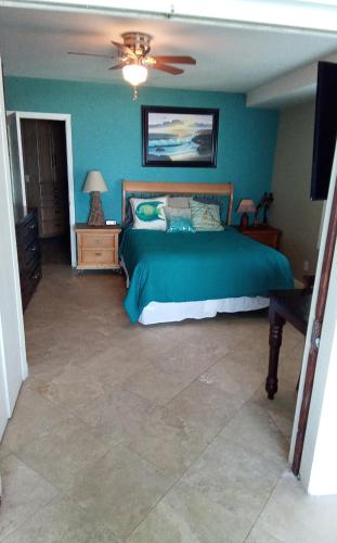a bedroom with a green bed and a ceiling fan at Breathtaking Oceana Del Mar in Rosarito