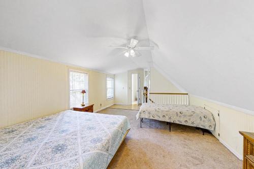 a bedroom with two beds and a ceiling fan at The Treehouse at 10th in Folly Beach