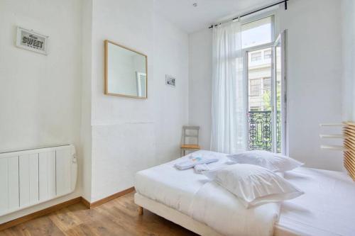 SCHUMAN 2 - Le bonheur de la Joliette في مارسيليا: غرفة نوم بيضاء بها سرير ونافذة