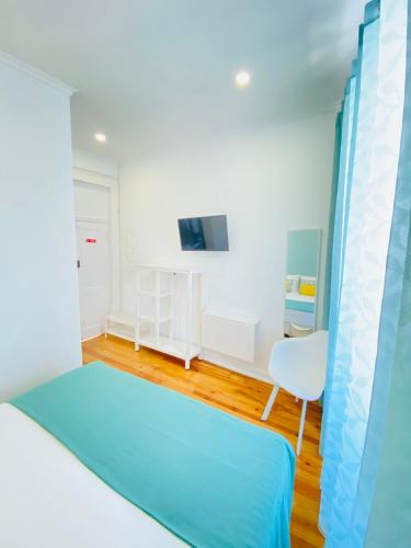 a bedroom with a bed and a table and a chair at Faro Guest House in Faro