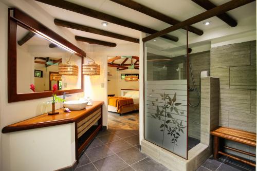 La salle de bains est pourvue d'une douche et d'un lavabo. dans l'établissement Villa Maya, à Flores