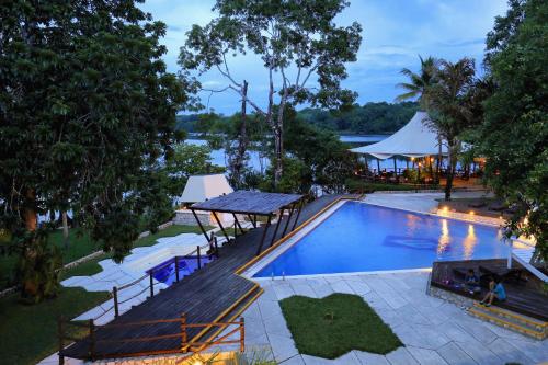 eine Aussicht über einen Pool mit einem Tisch und Bänken in der Unterkunft Villa Maya in Flores