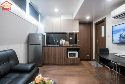 a kitchen and living room with a couch and a table at Merry House Imperia in Hai Phong