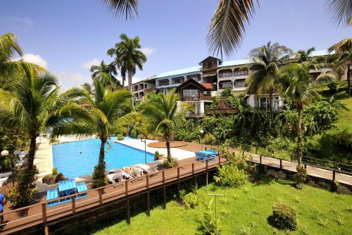 a view of a resort with a pool and palm trees at Villa Caribe in Lívingston