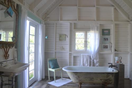 La salle de bains blanche est pourvue d'une baignoire et d'un lavabo. dans l'établissement Baviaanshoek, à Keurboomstrand