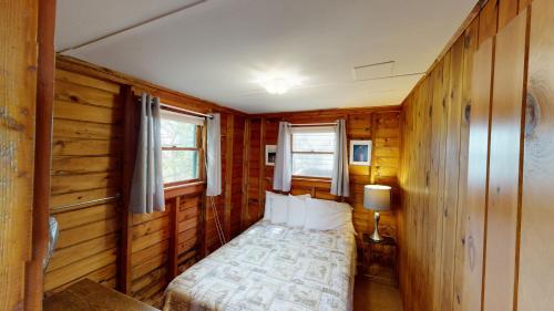 a bedroom with a bed in a wooden room at The Lakeview Inn & Cottages in Weirs Beach