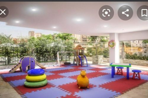 a play area with a playground with toys on it at Escape Apartments, Balcony, Pool, Gym & Spa in La Julia in Santo Domingo