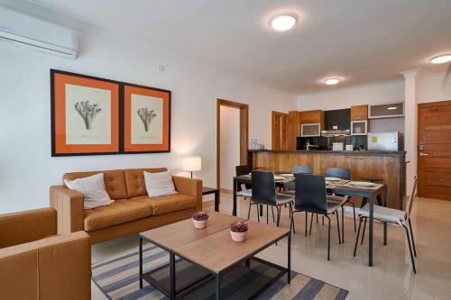 a living room with a couch and a table and chairs at Escape Apartments, Balcony, Pool, Gym & Spa in La Julia in Santo Domingo