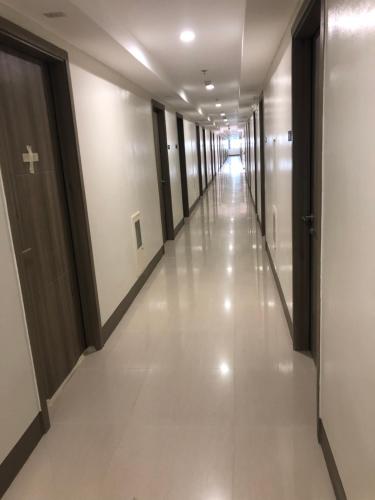 a hallway in a building with white floors and doors at Staycation in Manila
