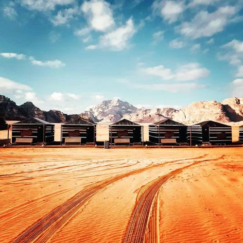 a building in the desert with mountains in the background at WADI RUM STAR WARS CAMP in Wadi Rum