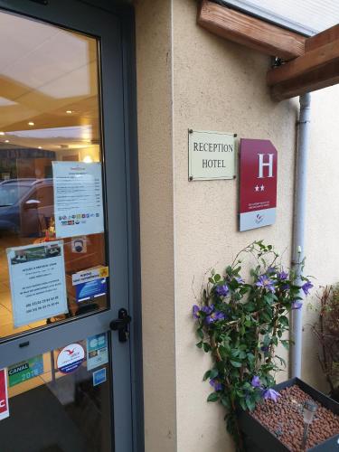 a door of a hotel with a plant next to it at Fasthôtel Le Râle Des Genêts - Un hôtel FH Collection in Dun-sur-Meuse