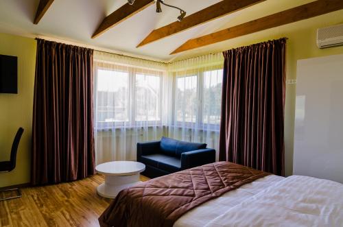 1 dormitorio con 1 cama, 1 silla y 1 ventana en Vilatekila-Lili Apartments, en Palanga
