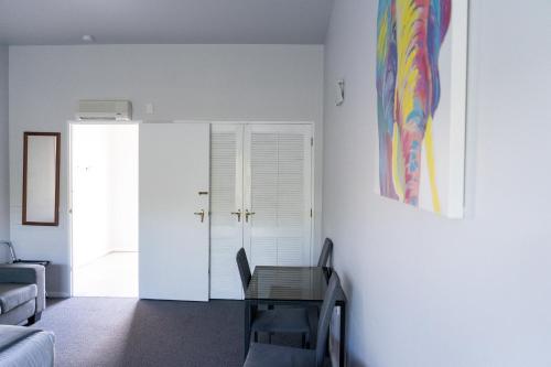 a living room with a table and a painting on the wall at Burwood Motel in Whanganui