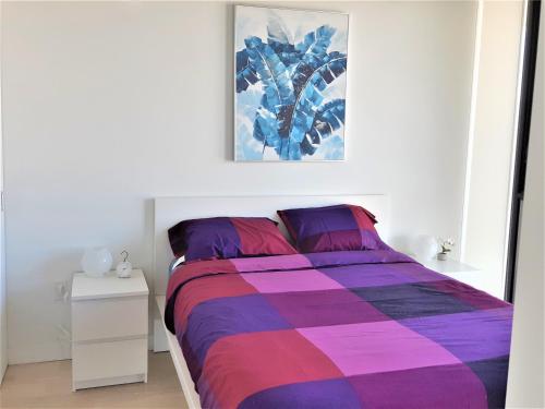 a bedroom with a bed with a purple and purple blanket at Luxury skyline condo in downtown FREE 24/7 parking in Winnipeg