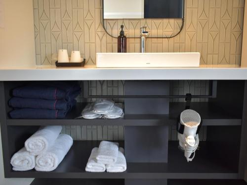 un bagno con lavandino e asciugamani sotto un bancone di THE LIVELY HONMACHI OSAKA / Vacation STAY 76687 ad Osaka
