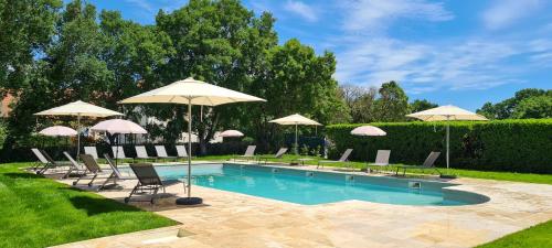 una piscina con sillas y sombrillas en Logis Hotel Bellaroc en Rocamadour