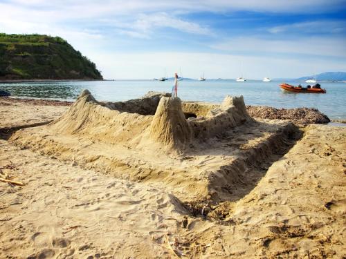 a sand castle on a beach next to the water at Apartments VESNA (63) in Veli Lošinj