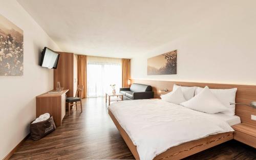 une chambre d'hôtel avec un lit et une chaise dans l'établissement AMELIA rooms, à Tirolo