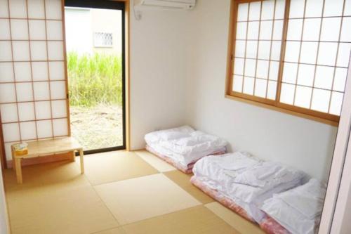 two beds in a room with two windows at 風車村3-G-1B号棟 in Aiba