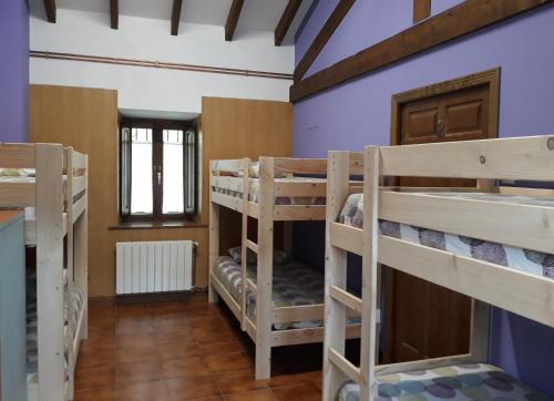 a room with several bunk beds in a house at Albergue La Vargona in Camaleño