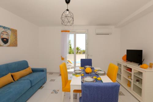 a living room with a blue couch and a table at Casa Floriana Seaview in Capri