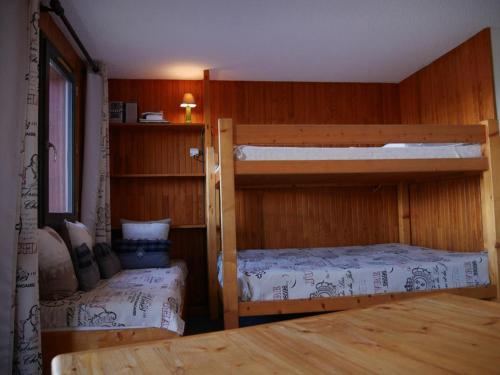 two bunk beds in a room with wooden walls at Studio Bellentre, 1 pièce, 3 personnes - FR-1-329-3 in Bellentre
