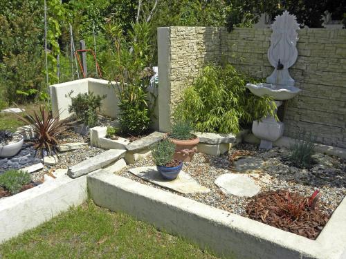 a garden with potted plants and a sink at Villa Mogador Piscine et Balnéo in Andernos-les-Bains
