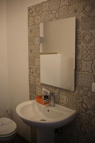 La salle de bains est pourvue d'un lavabo, d'un miroir et de toilettes. dans l'établissement Tourism E Business Superior Rooms, à Padoue