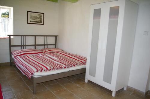 1 dormitorio con cama y pared blanca en Roubenka Ruzova, en Růžová