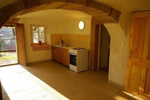 a kitchen with a white stove top oven next to a window at Roubenka Ruzova in Růžová