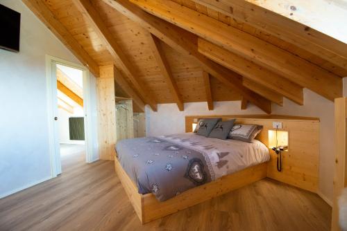 a bedroom with a bed in a room with wooden ceilings at Villa Ciardi Wellness Hotel & Ristorante in Roana