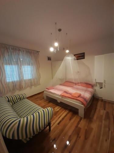 a bedroom with a bed and a couch in it at Bella Badacsony Apartmanház in Badacsonytomaj
