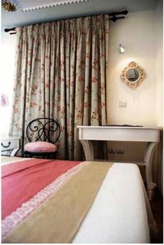 a bedroom with a bed and a table and a window at Arhontiko Pepos in Nafpaktos