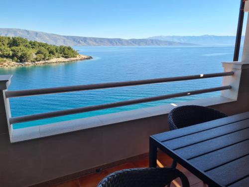 a balcony with a bench and a view of the water at Apartments Habek in Vrboska