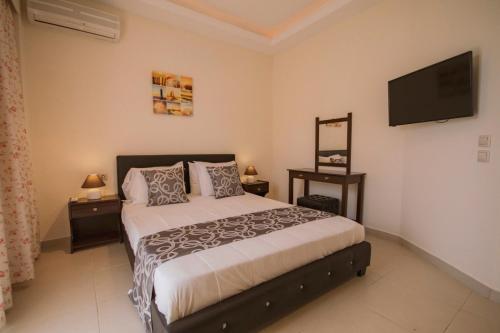 a bedroom with a bed and a flat screen tv at Anna Studios in Agios Georgios