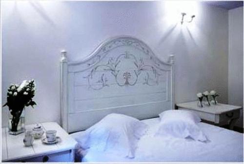 a bedroom with a white bed with a white headboard at Arhontiko Pepos in Nafpaktos