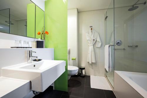 a bathroom with a sink and a toilet and a shower at Crowne Plaza Tel Aviv City Center by IHG in Tel Aviv