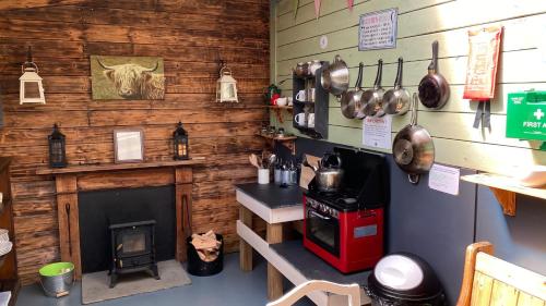 a kitchen with a fireplace and a cow head on the wall at Skye Eco Bells in Dunvegan